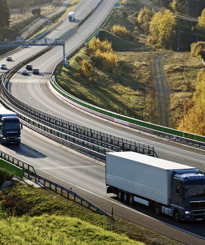 Vrachtwagens op snelweg door natuurlandschap | Werken bij Seacon Logistics 